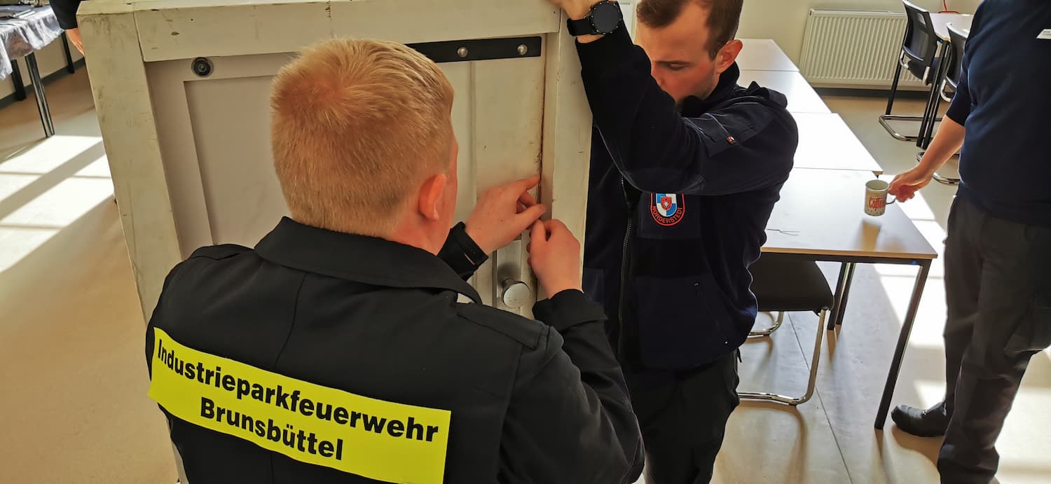 Zwei Feuerwehr Anwärter bei einer Übung zur Türöffnung.